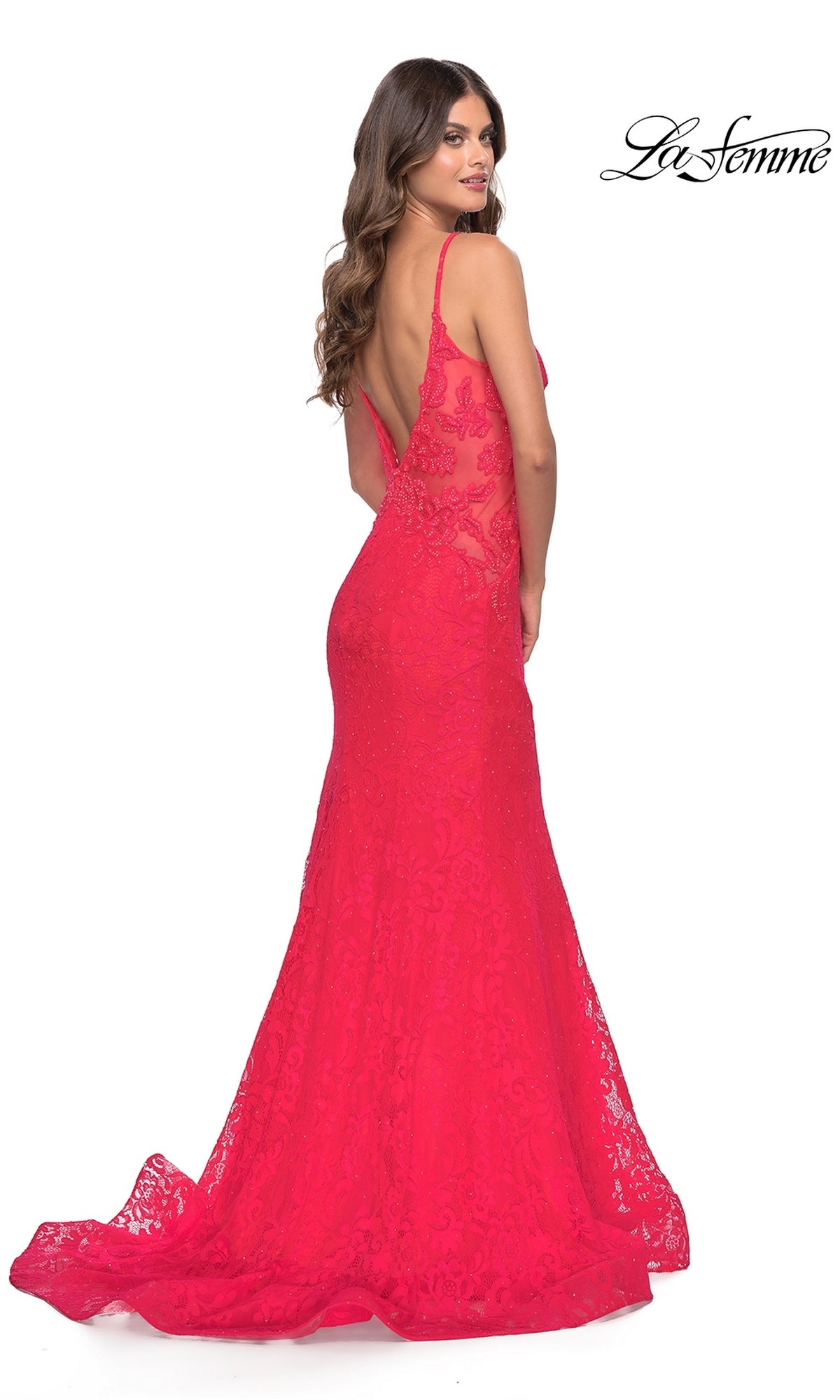 Woman posing in the La Femme 31512 Long Lace Mermaid Prom Dress—bright pink, floor-length with lace detail and an open back—looking over her shoulder.